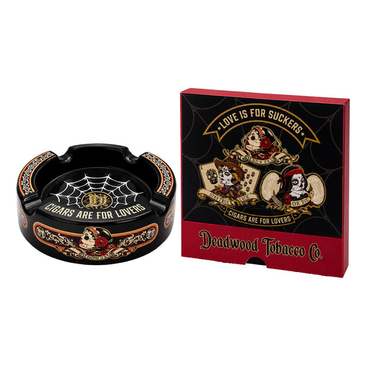 Black ashtray with decorative design and 'Deadwood Tobacco Co.' packaging on a white background