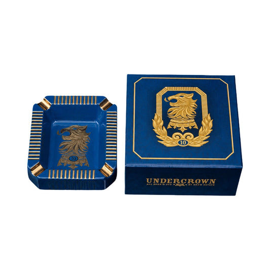 Blue and gold Undercrown branded ashtray and box on a white background